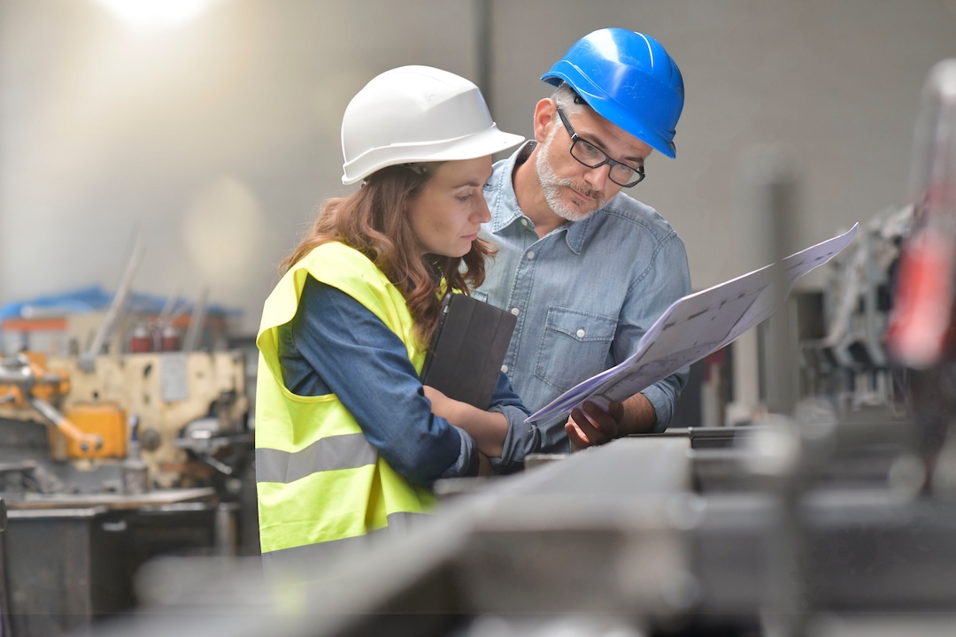 Female and male engineering looking at documentation