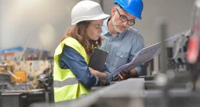 Female and male engineering looking at documentation